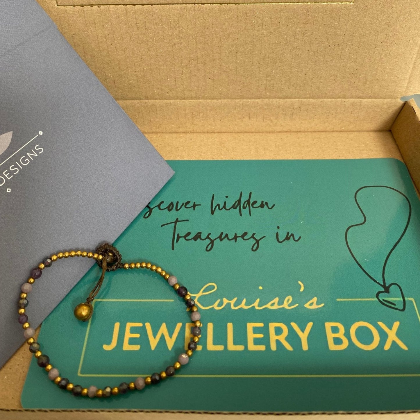 Amethyst beaded healing bracelet for anxiety with gold accents from an unbranded jewellery box.
