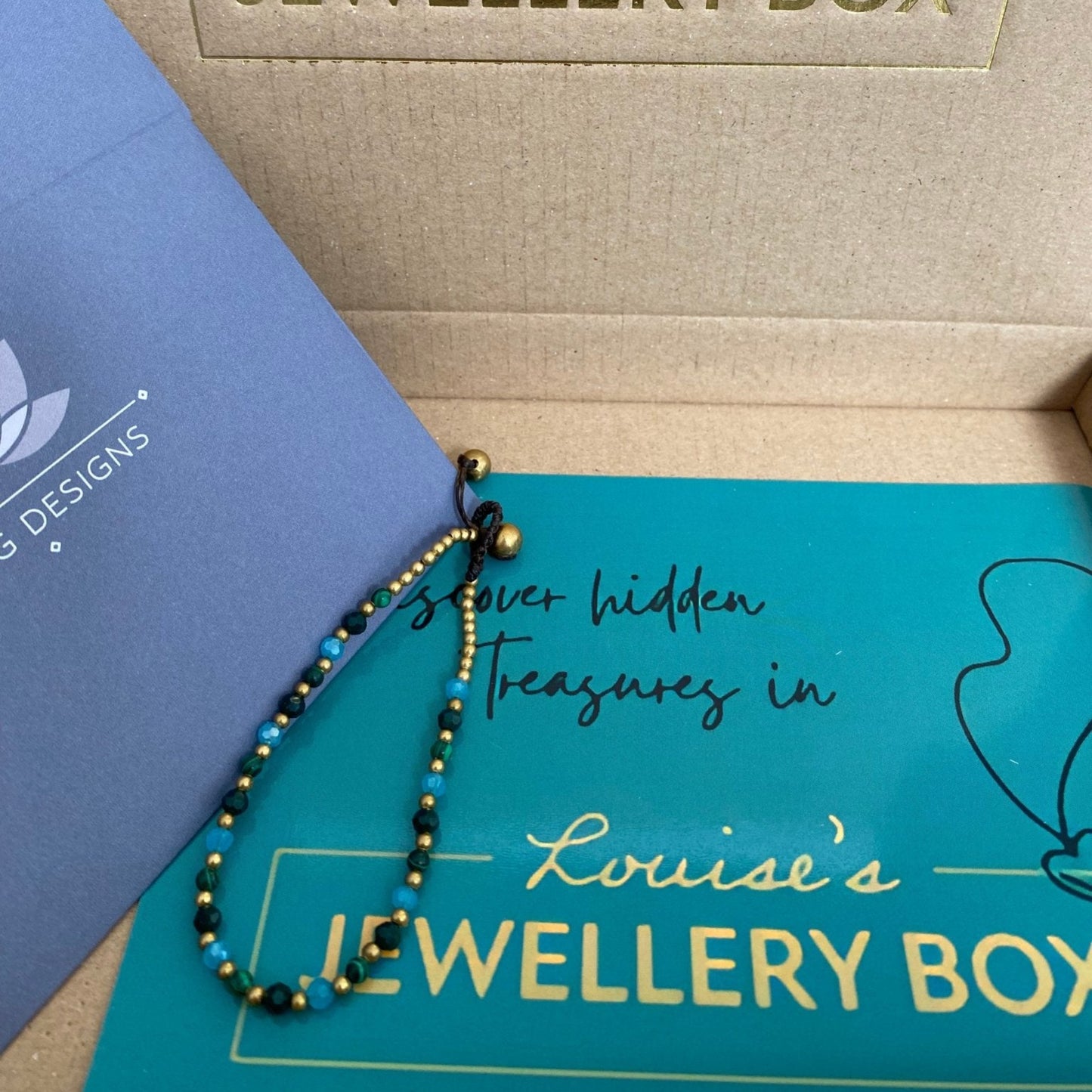 Beaded bracelet for protection with malachite crystal, shown with gold beads and tassels.