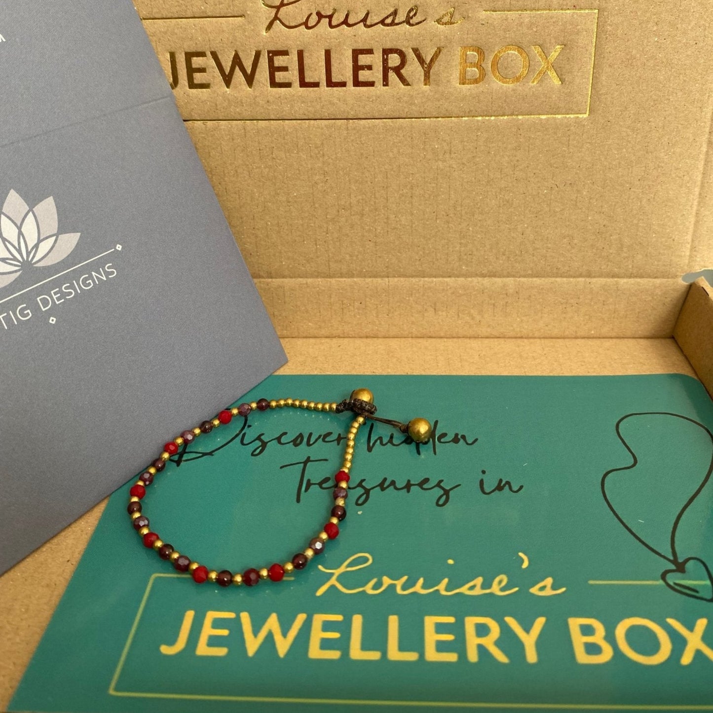 Beaded pink agate crystal healing bracelet for love with gold accents, inside a branded jewelry box.