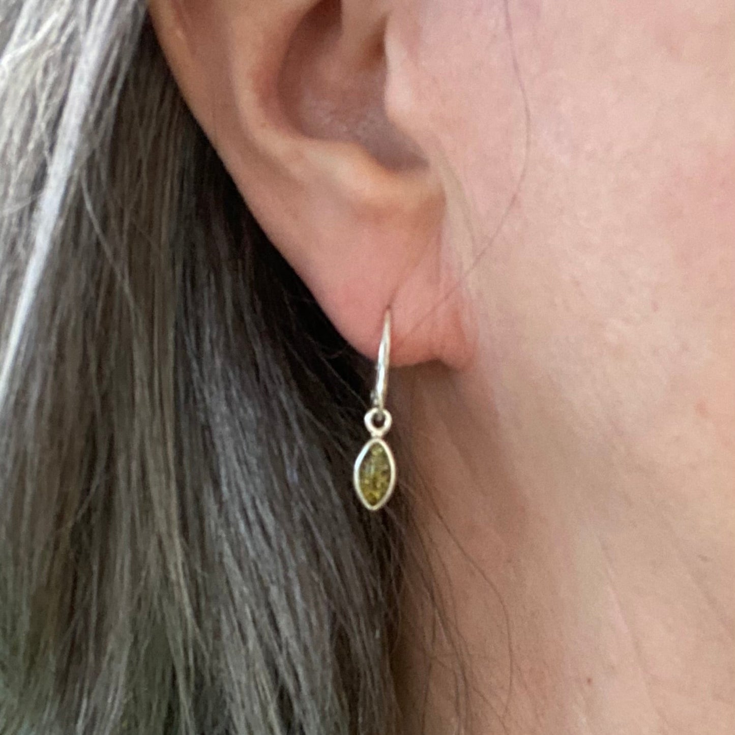 Sterling silver silver leaf-shaped drop earrings with green Baltic amber detail view

