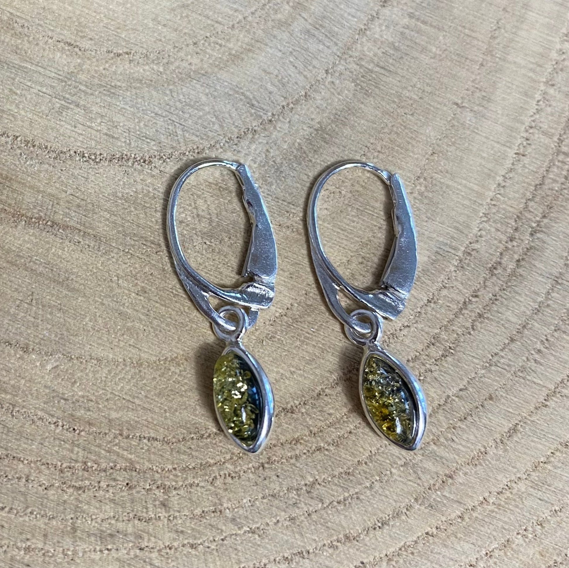 Close-up of marquise-cut green Baltic amber in sterling silver leaf earrings

