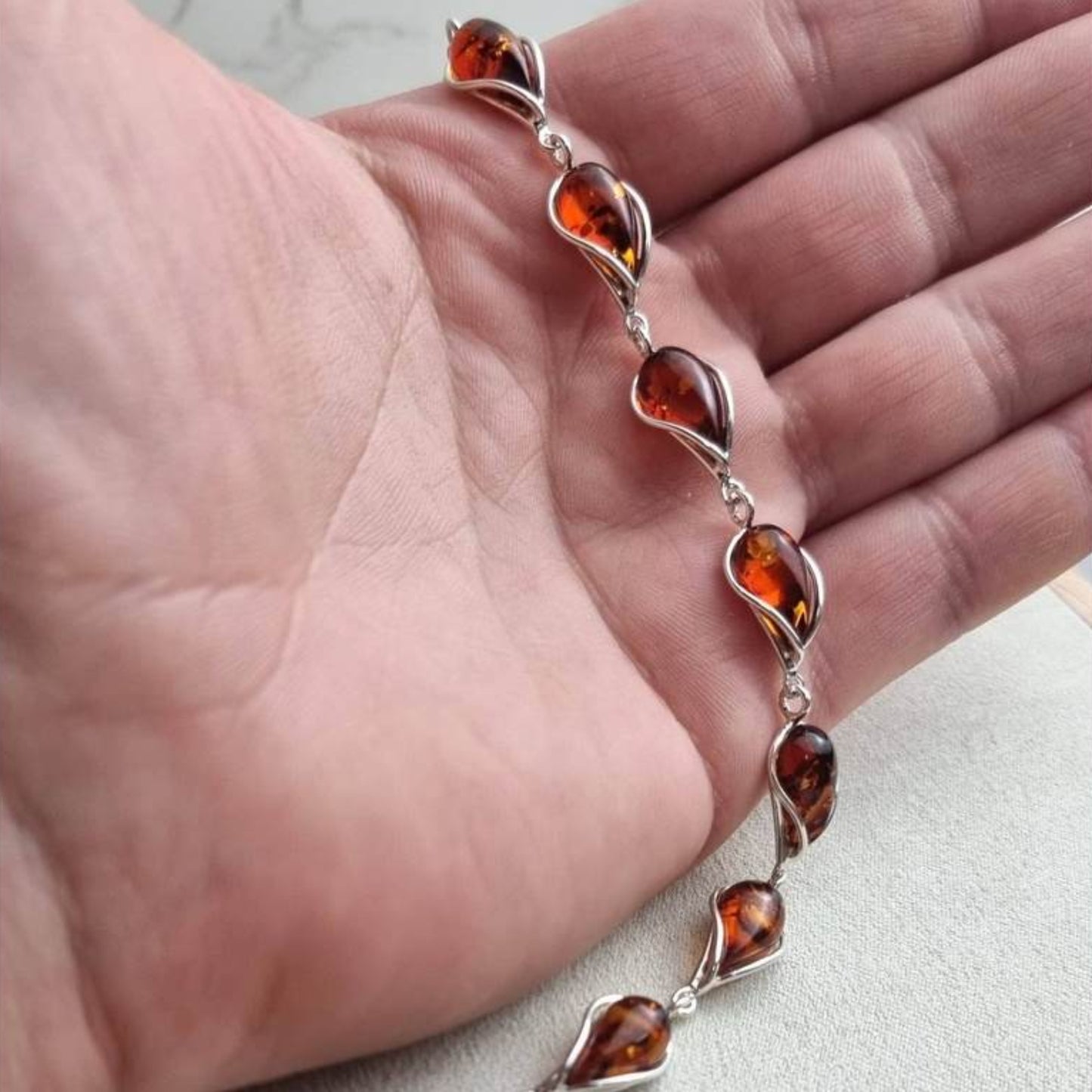 Cognac Baltic amber bracelet in sterling silver with twisted silver frames surrounding each amber stone.