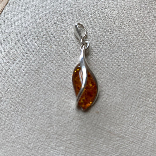 Cognac Baltic amber pendant in sterling silver by Baltica, in a twisted teardrop shape.