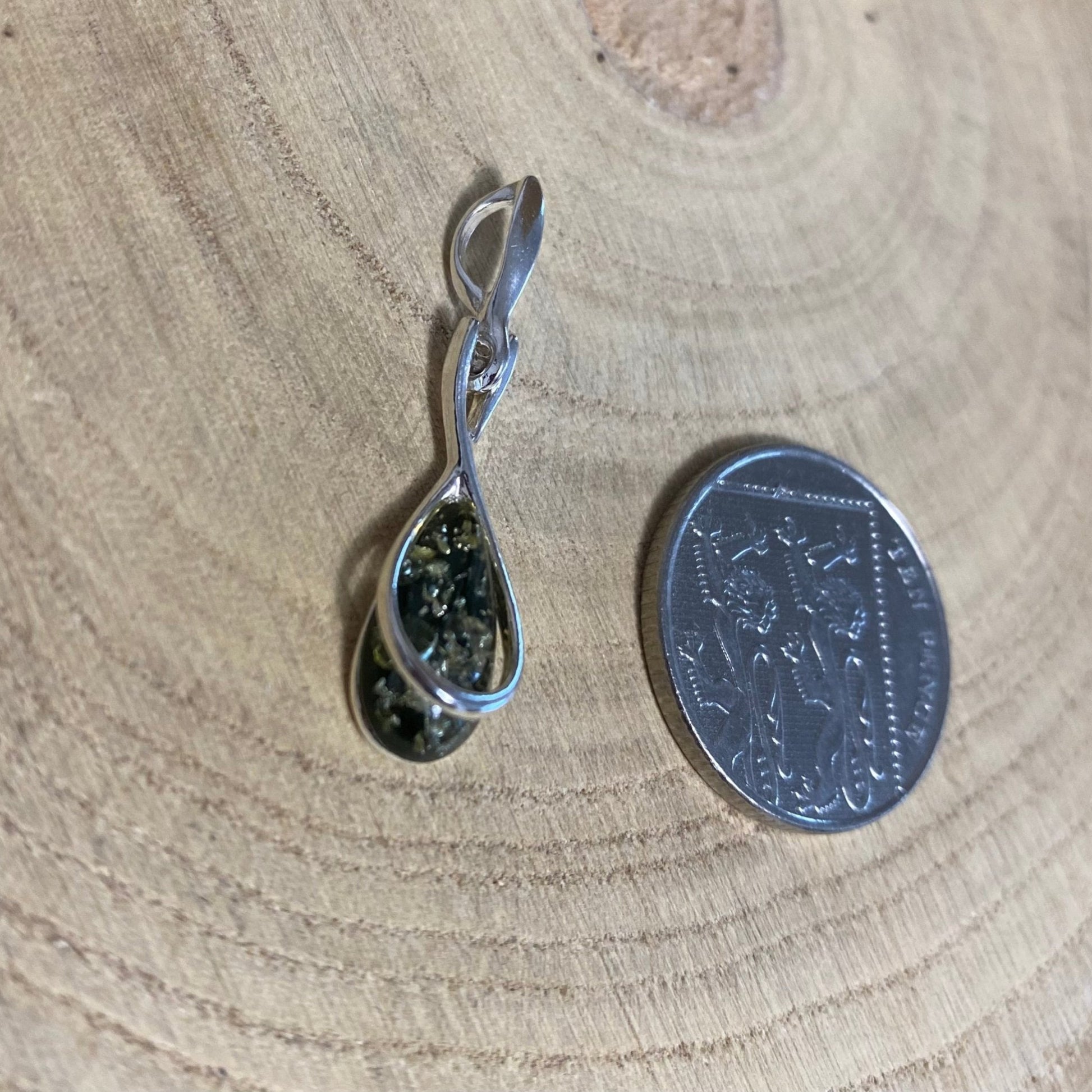 Close-up of green Baltic amber in modern sterling silver teardrop pendant

.