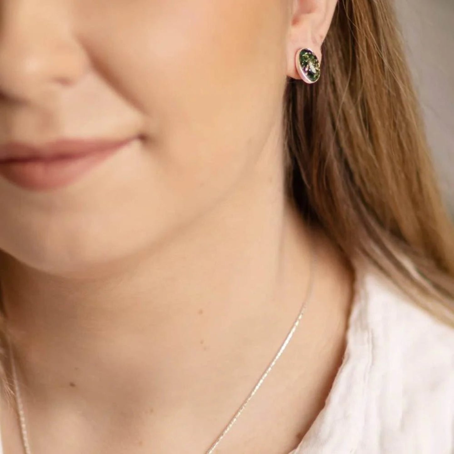 Green Baltic amber oval studs in sterling silver worn on ear

